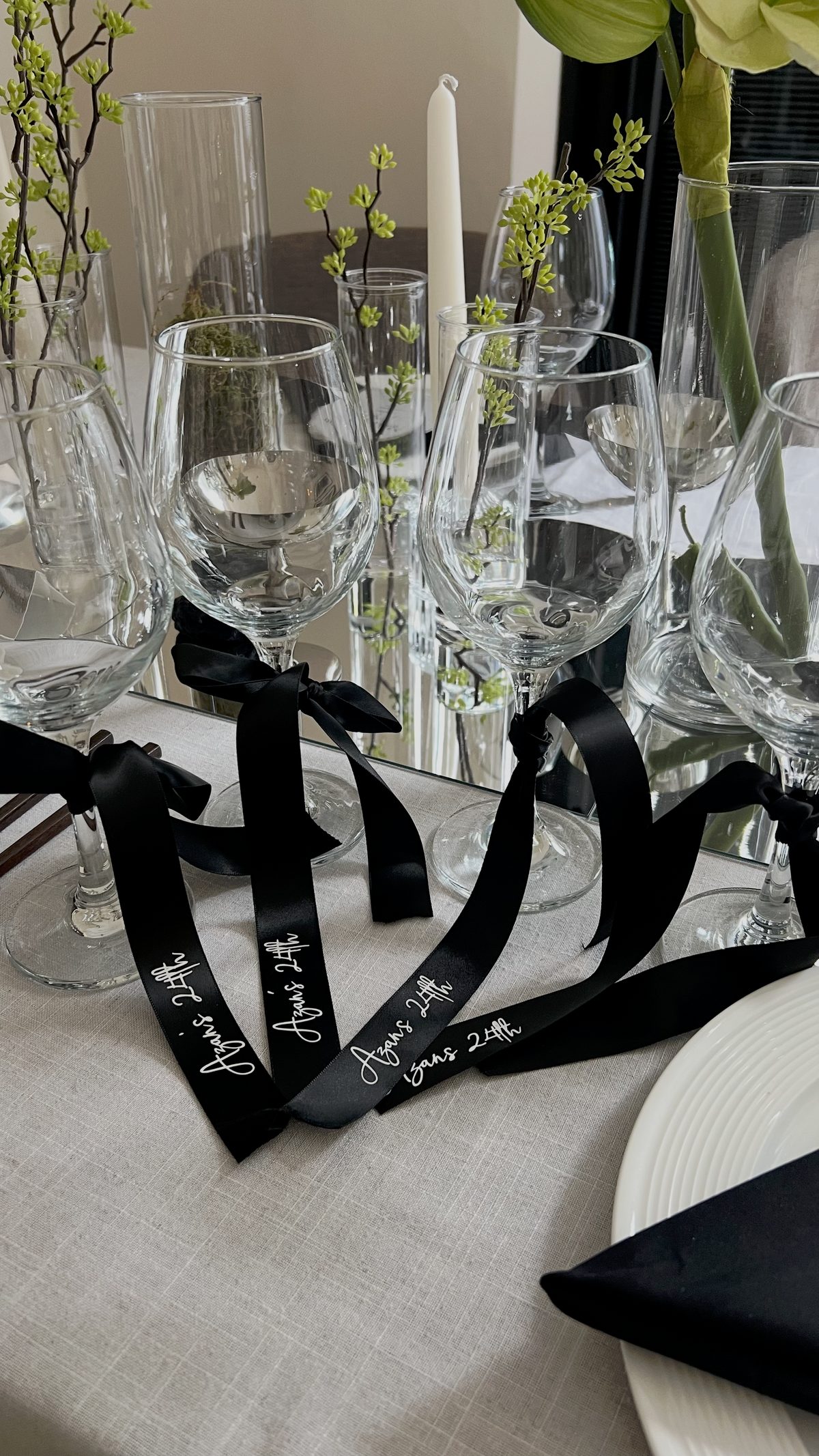 Personalised black satin name ribbons tied to wine glasses
